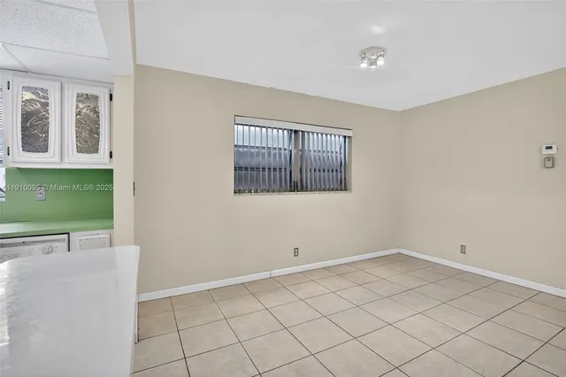 a view of an empty room with chandelier fan