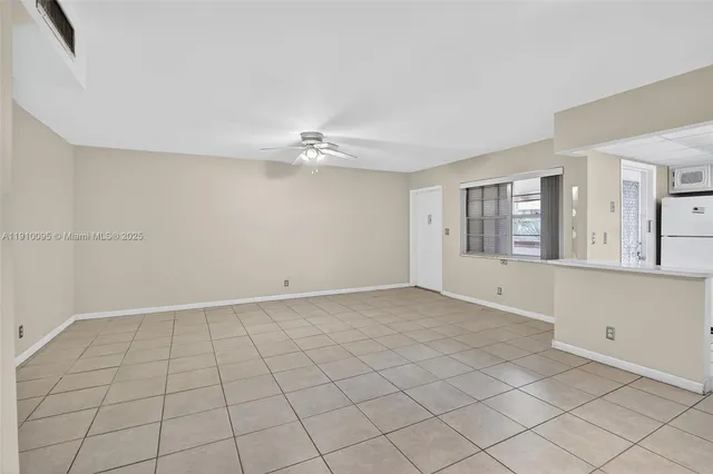 an empty room with a ceiling fan and carpet