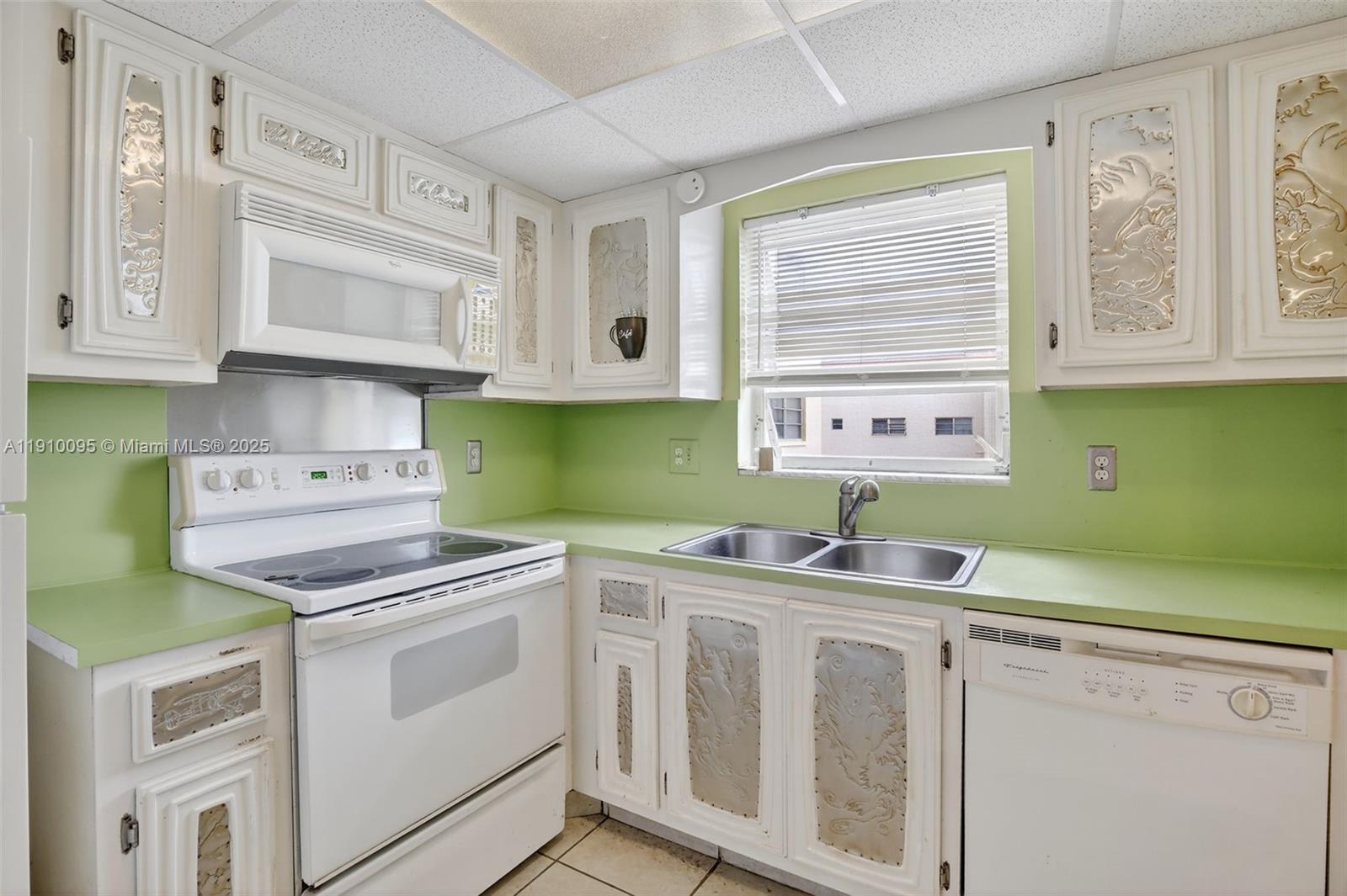 5300 Washington Street, Unit T218 Hollywood, FL 33021 - Photo 9 of 36 a kitchen with cabinets appliances a sink and a window