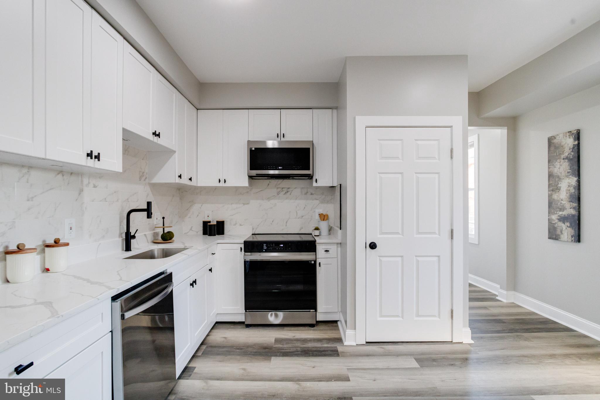 1534 Homestead Street Baltimore, MD 21218 - Photo 15 of 48 a kitchen with stainless steel appliances granite countertop a stove top oven a sink and a refrigerator