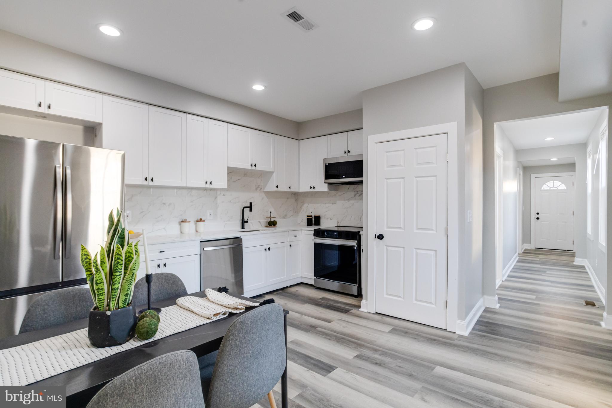 1534 Homestead Street Baltimore, MD 21218 - Photo 9 of 48 a kitchen with stainless steel appliances kitchen island granite countertop a refrigerator a stove a sink dishwasher and white cabinets with wooden floor
