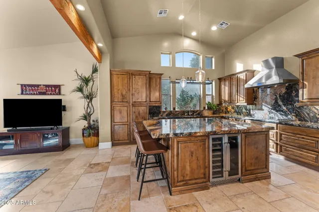 a kitchen with stainless steel appliances granite countertop a stove a sink dishwasher and a refrigerator with wooden floor