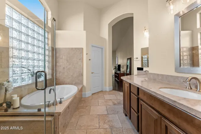 a bathroom with a granite countertop sink mirror and bathtub