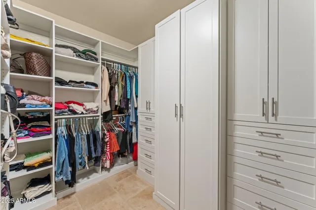 a view of walk in closet with clothes