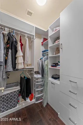 a view of walk in closet with clothes and shoes
