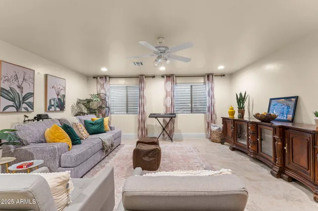 a living room with furniture a wooden floor and a large window