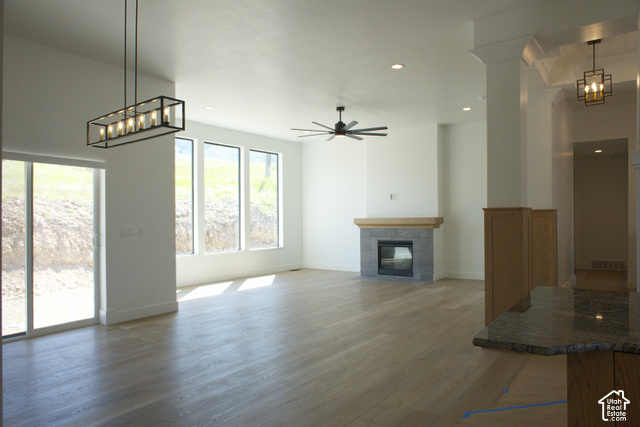 3504 North Sun Dancer Loop Logan, UT 84341 - Photo 11 of 59 Spacious living area featuring wood-finish flooring, a fireplace with a stone surround and wood mantel, multiple large windows, and a sliding glass door