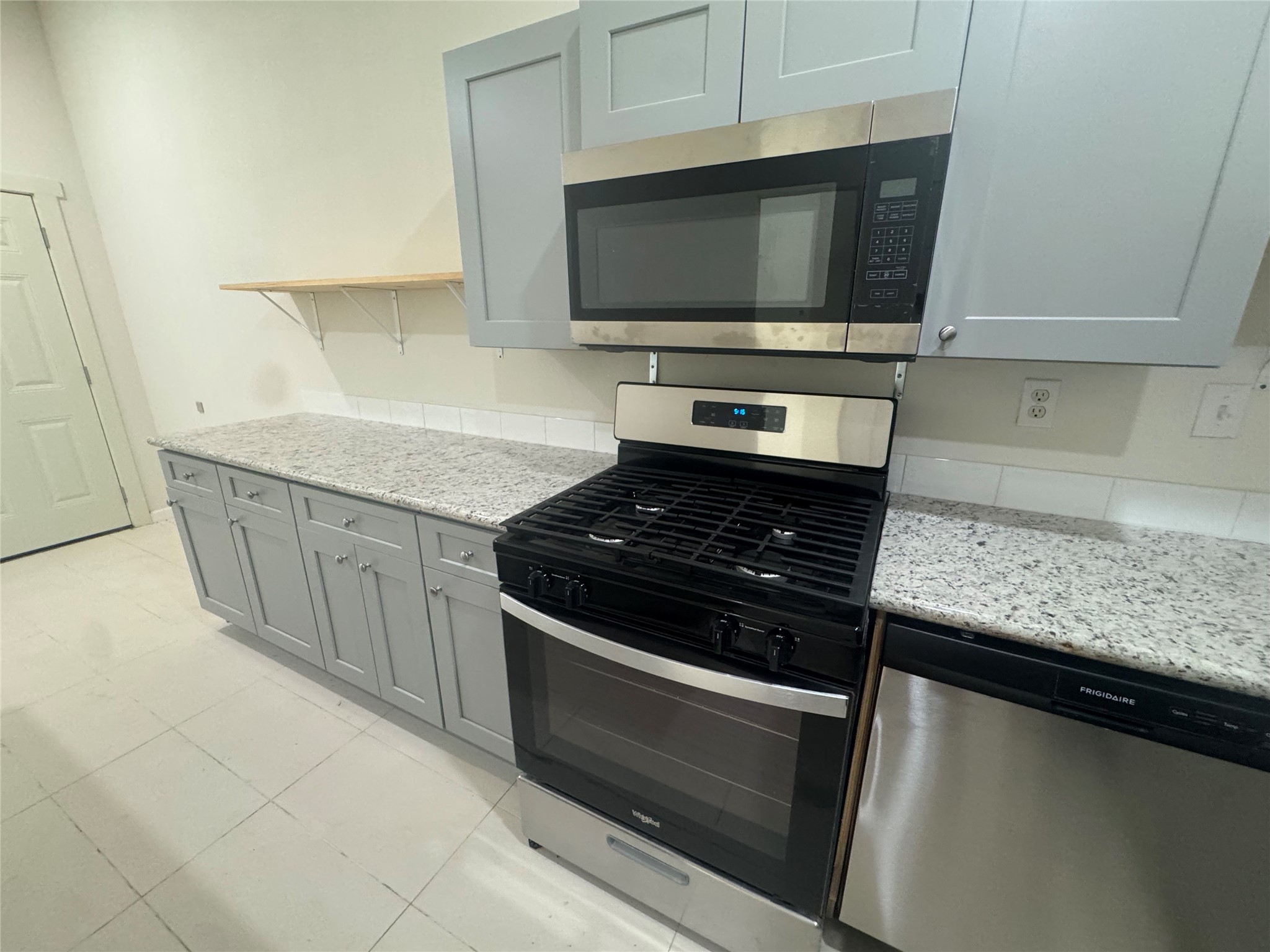 1443 Willow Rock Road Houston, TX 77088 - Photo 13 of 27 a kitchen with granite countertop a stove and a microwave