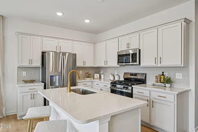 a kitchen with kitchen island a white cabinets and refrigerator