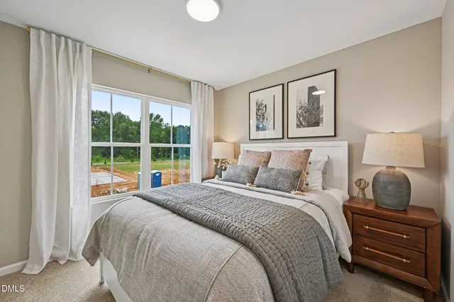 a bedroom with bed and a painting on the wall