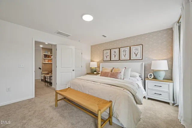 a bedroom with a bed a mirror on dresser and a window