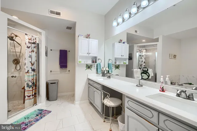 a spacious bathroom with a double vanity sink mirror and shower