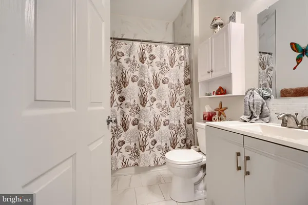 a bathroom with a toilet sink and shower curtain