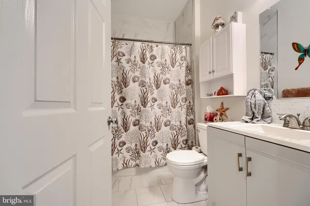 a bathroom with a toilet sink and shower curtain