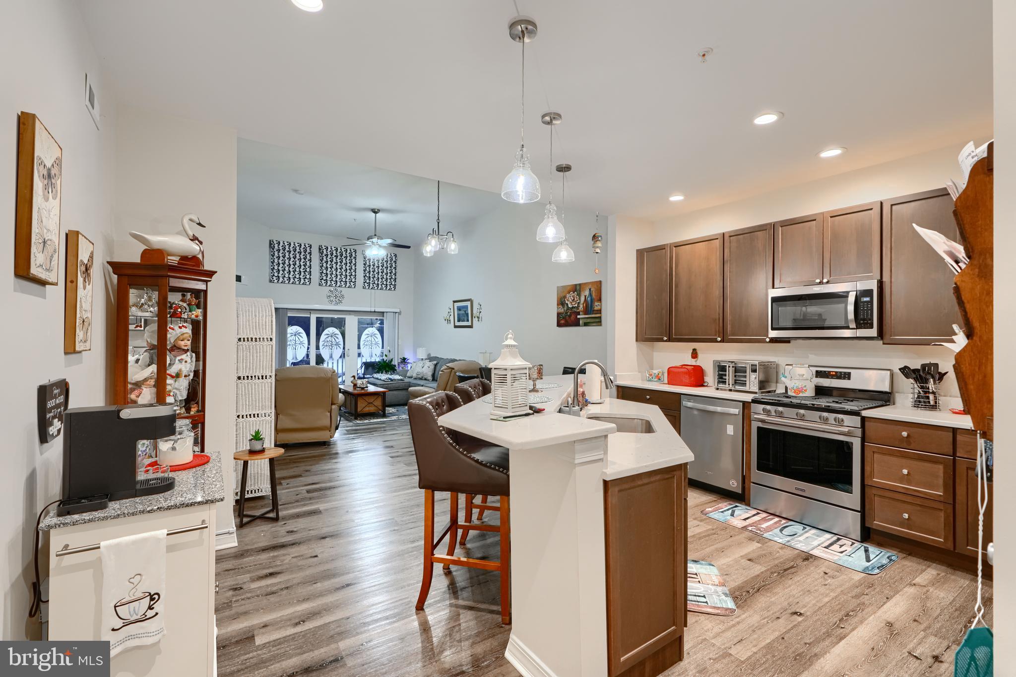 231 Roundhouse Drive, Unit 3E Perryville, MD 21903 - Photo 3 of 38 a kitchen with stainless steel appliances kitchen island granite countertop a sink dishwasher stove top oven and cabinets with wooden floor