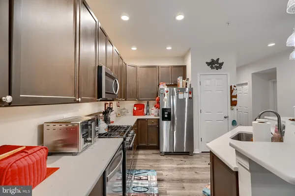 a kitchen with stainless steel appliances kitchen island granite countertop a refrigerator and a stove top oven