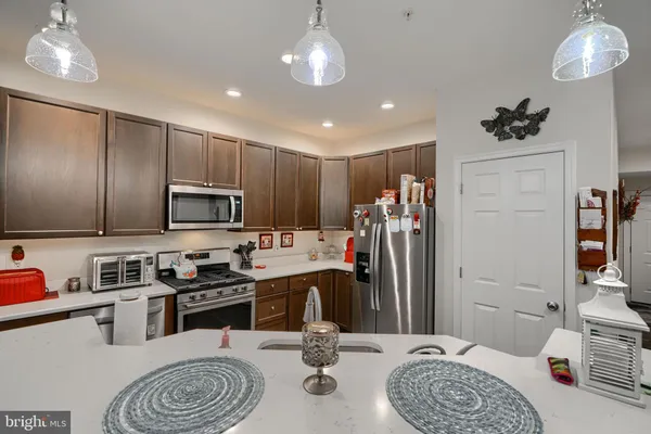 a kitchen with stainless steel appliances granite countertop a refrigerator sink and stove