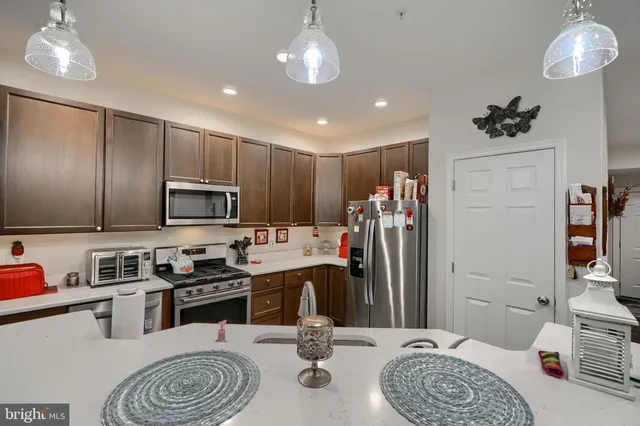 a kitchen with stainless steel appliances granite countertop a refrigerator sink and stove