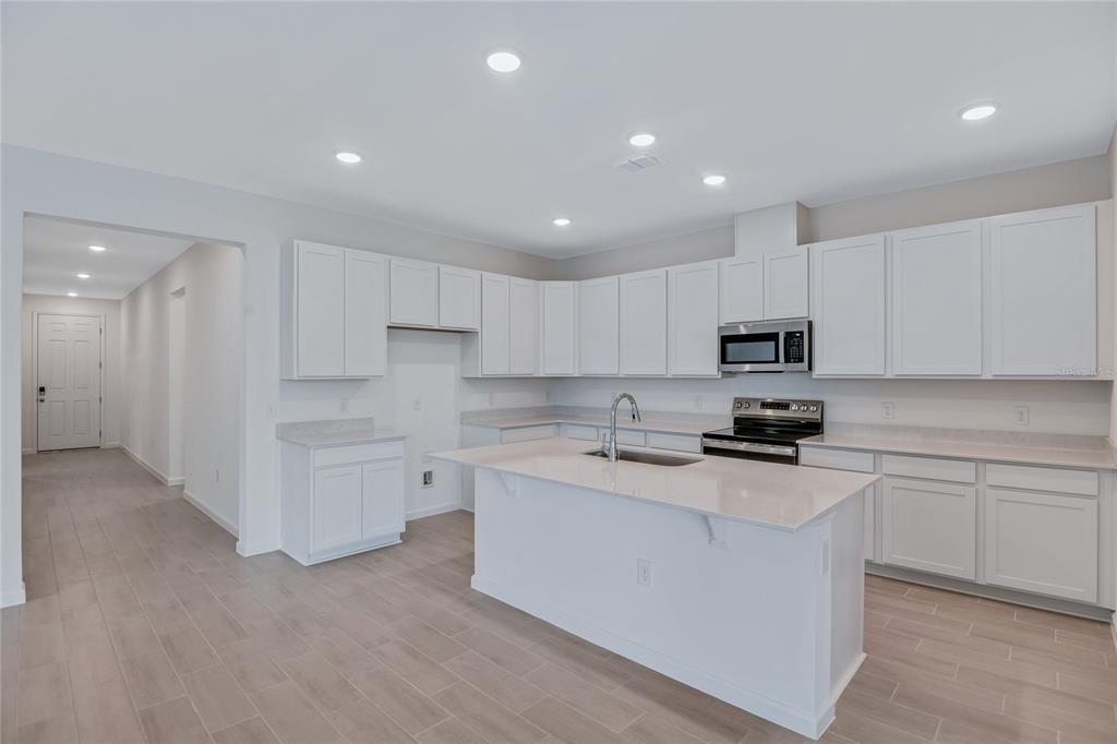 5347 Mickey Avenue Lake Wales, FL 33859 - Photo 6 of 18 a kitchen with white cabinets and stainless steel appliances