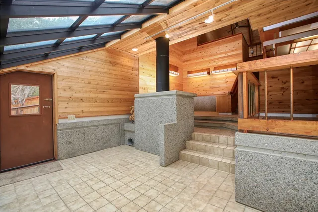 a view of a livingroom with wooden floor ceiling fan and windows