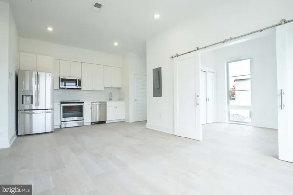 a view of a kitchen with a sink and a refrigerator