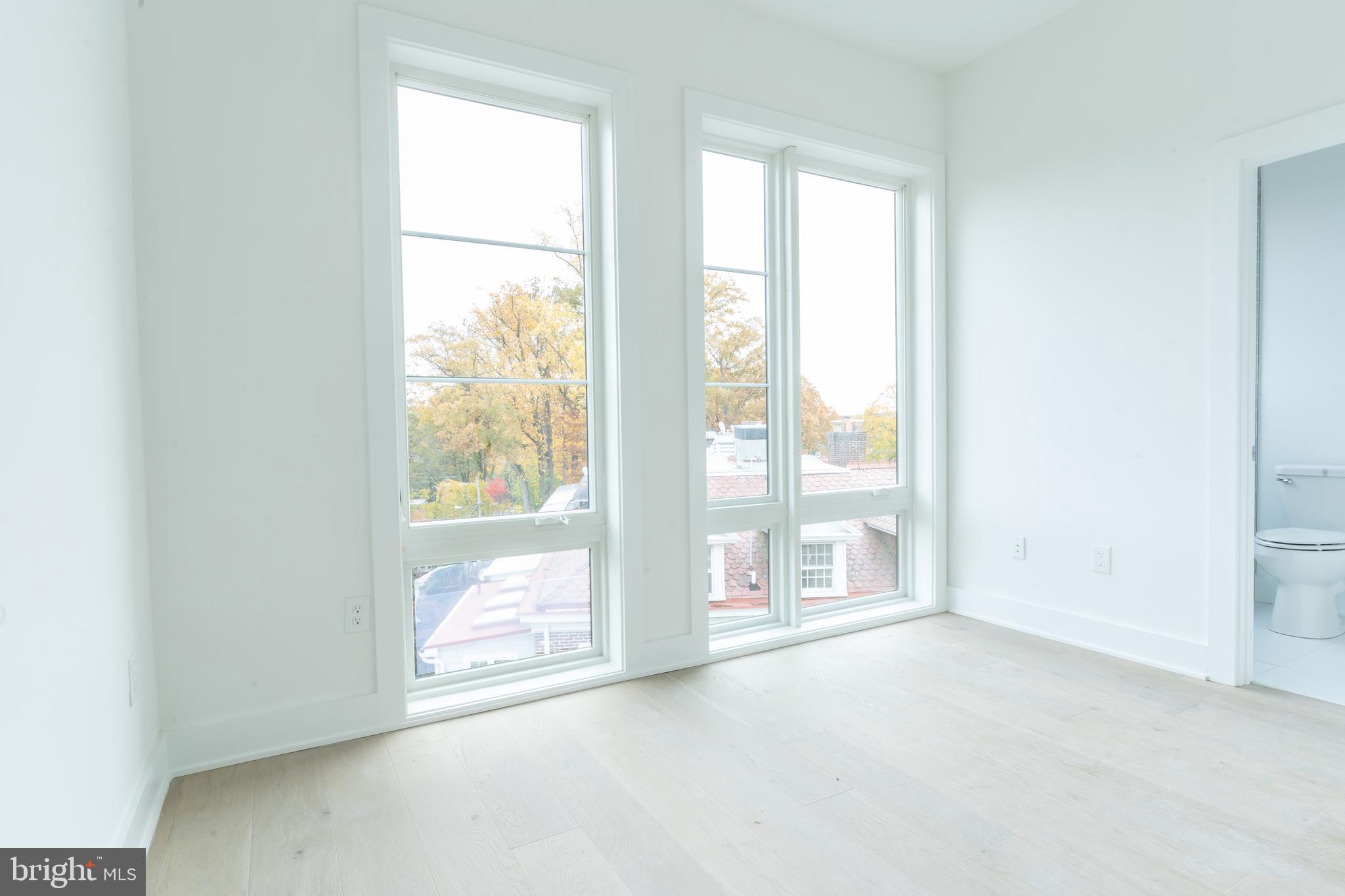 5301 Connecticut Avenue Northwest, Unit 403 Washington, DC 20015 - Photo 6 of 12 a view of an empty room with wooden floor and a window