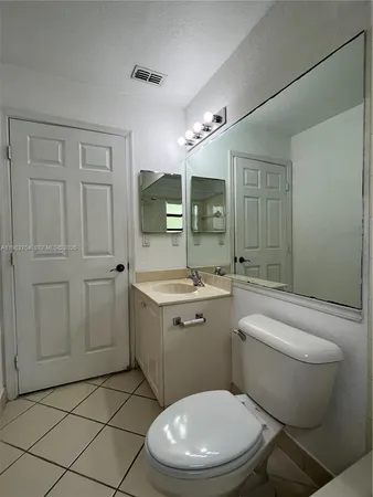 a bathroom with a toilet a sink and mirror