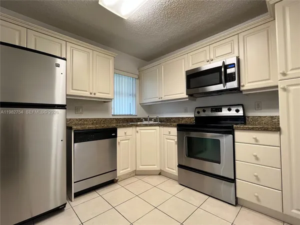 a kitchen with white cabinets stainless steel appliances and a sink