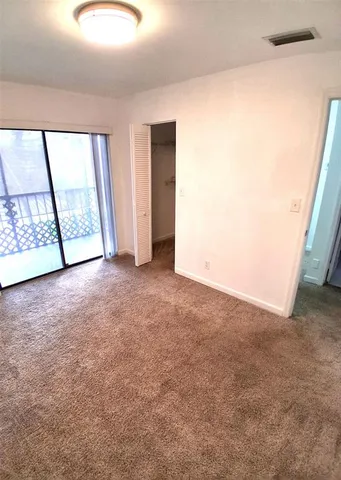 an empty room with windows and closet