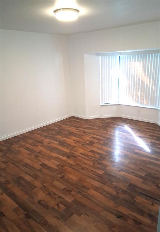 2718 South University Drive, Unit 17B Fort Lauderdale, FL 33328 - Photo 23 of 28 a view of an empty room with wooden floor and a window