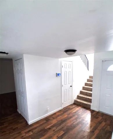 a view of a livingroom with wooden floor and stairs