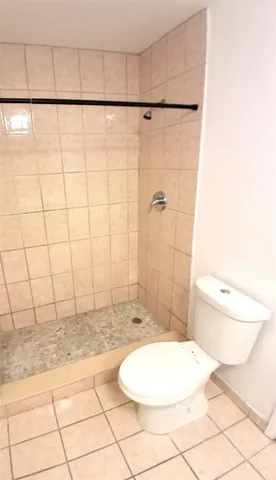 a bathroom with a toilet and a shower