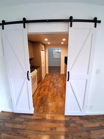 a view of a hallway with wooden floor and staircase