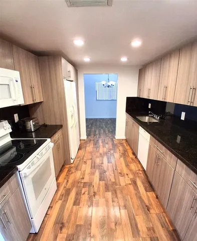 a kitchen with stainless steel appliances granite countertop a sink stove and cabinets