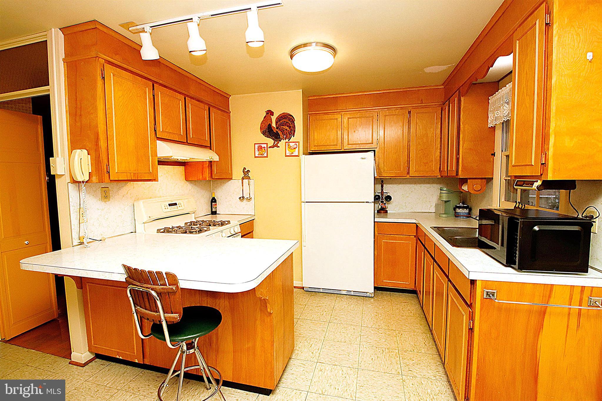 414 Beaver Creek Road Hagerstown, MD 21740 - Photo 11 of 33 a kitchen with refrigerator a stove a sink dishwasher and wooden cabinets