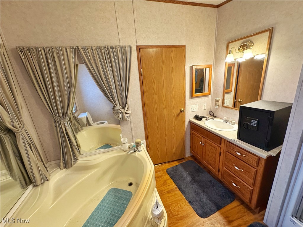 72117 Barton Road Bridgeport, OH 43912 - Photo 14 of 42 Full bath with a garden tub, vanity, and light wood-style floors
