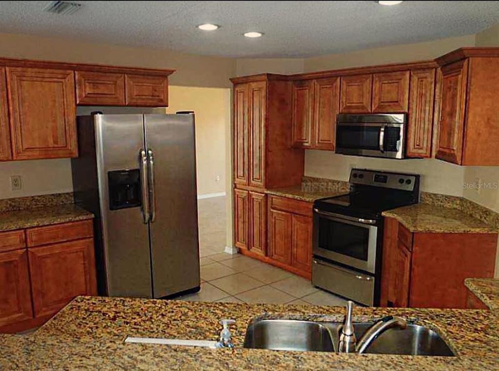 13625 Deventer Court Hudson, FL 34667 - Photo 10 of 14 a kitchen with stainless steel appliances granite countertop a refrigerator and a stove top oven