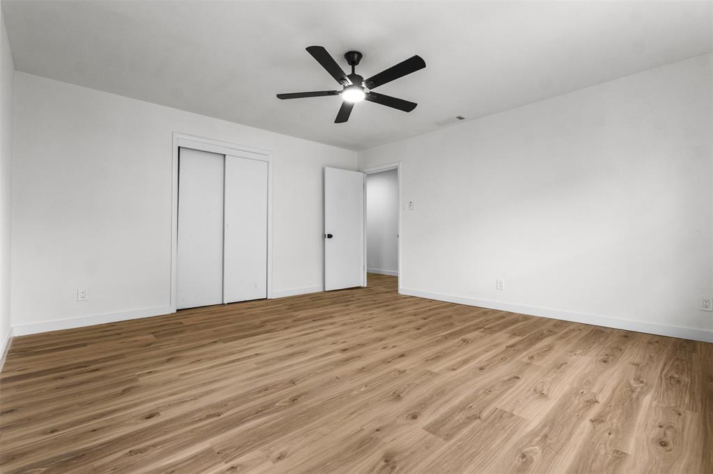 1917 South Vernon Avenue Dallas, TX 75224 - Photo 24 of 28 Bright room featuring wood-finish flooring, a contemporary ceiling fan with integrated lighting, a sliding door closet, and neutral wall tones