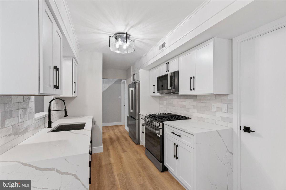21 Andover Circle Princeton, NJ 08540 - Photo 9 of 31 a kitchen with stainless steel appliances a sink stove and cabinets
