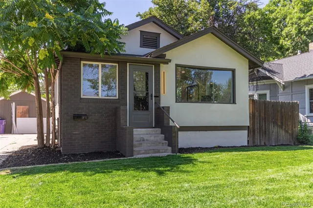 a view of a house with a small yard and wooden fence