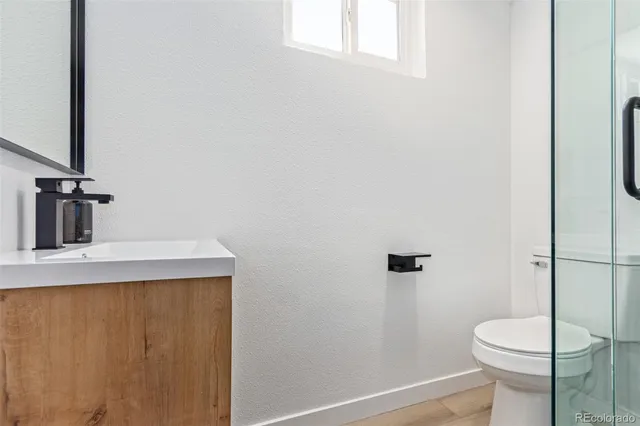 a bathroom with a sink a toilet and shower