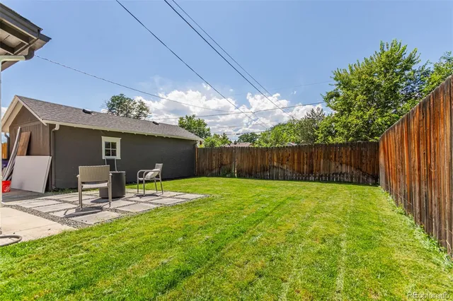 a backyard of a house with table and chairs