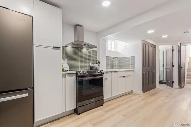 a kitchen with stainless steel appliances a refrigerator and a stove top oven
