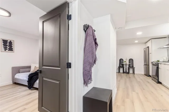 a hallway with a couch and a dining table with wooden floor