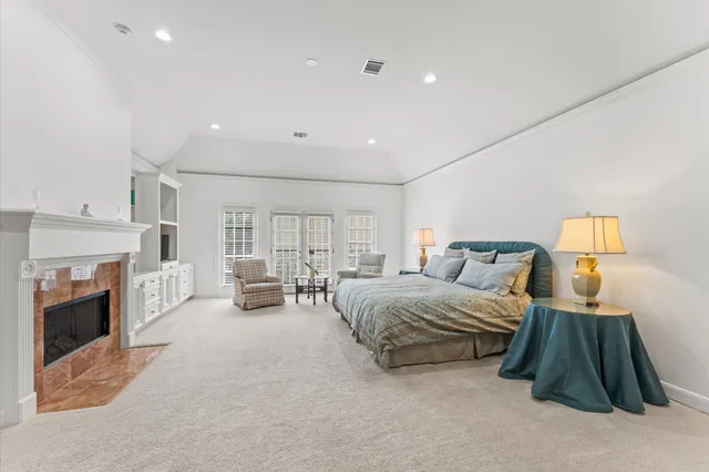 a spacious bedroom with a bed a couch and a fireplace