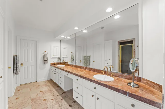 a spacious bathroom with a granite countertop double vanity sink mirror and