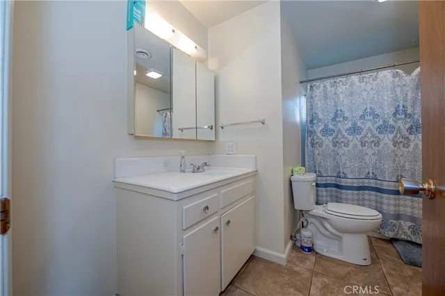 a bathroom with a granite countertop sink a toilet and a shower