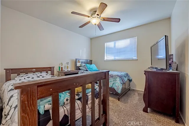 a bedroom with furniture and a chandelier fan