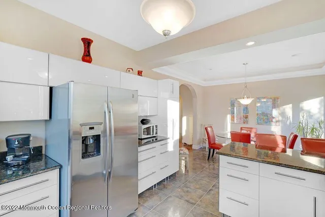 a kitchen with stainless steel appliances kitchen island granite countertop a refrigerator and a sink