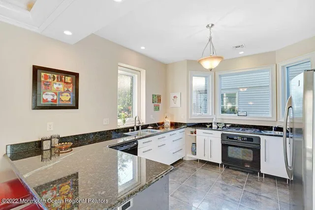 a large kitchen with granite countertop a stove and a sink